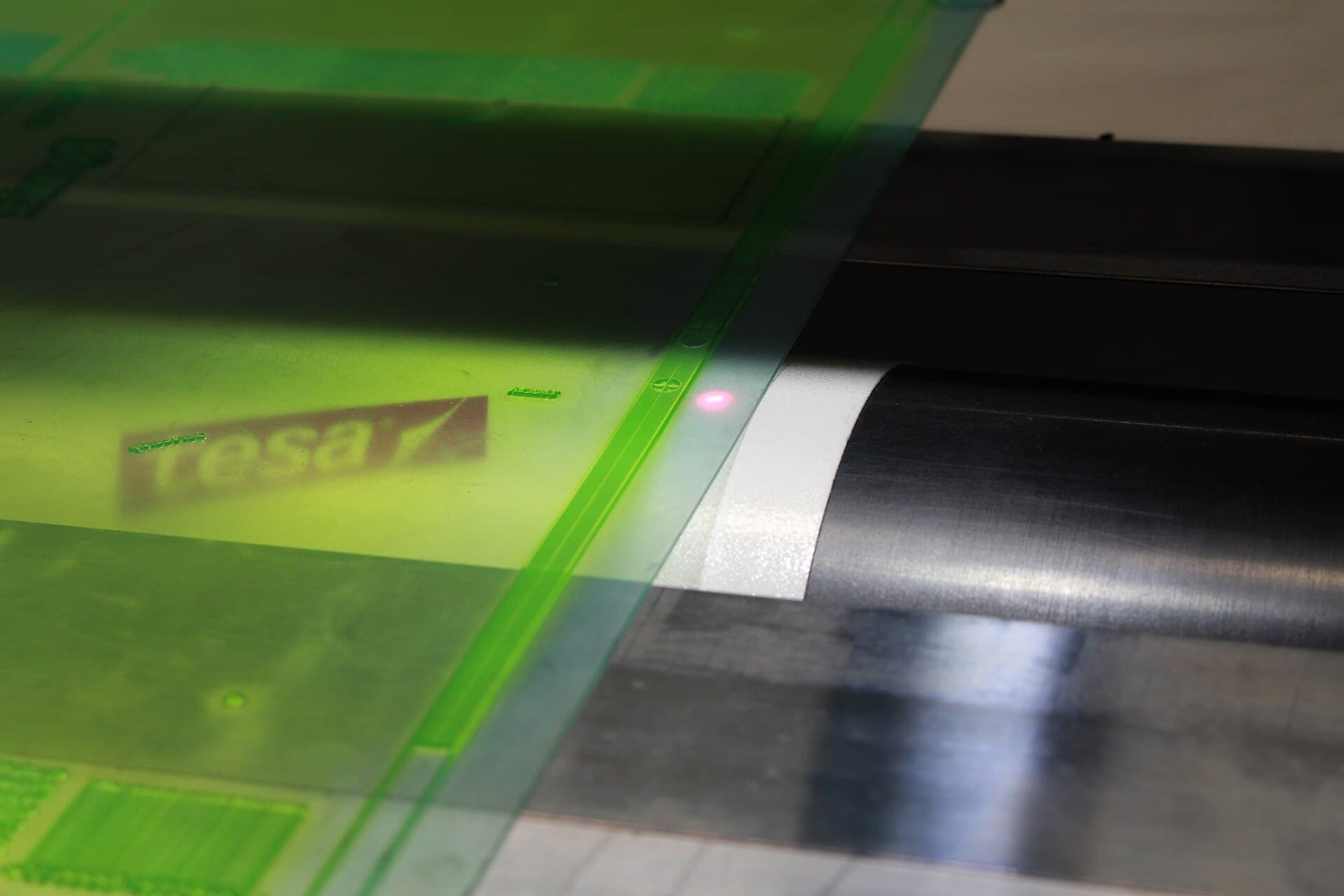 Pelat flexografi yang disejajarkan pada meja mounting industri dengan register laser